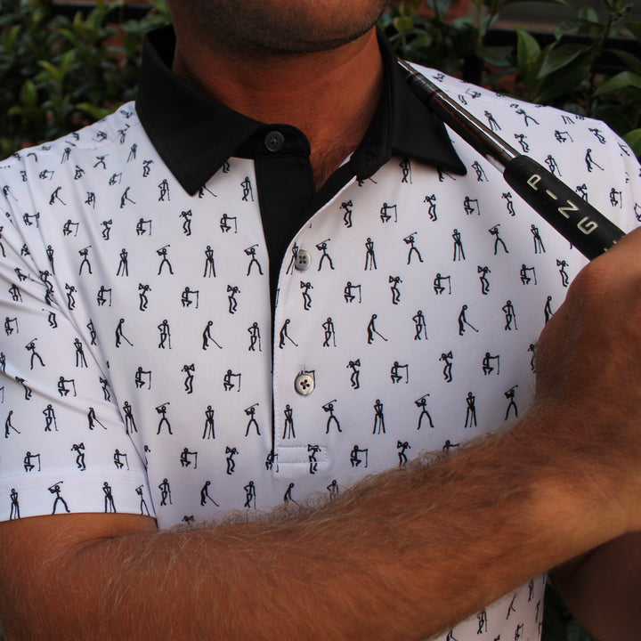 A white performance golf polo with a black collar. The pattern is black stick figure golfers on a white polo.